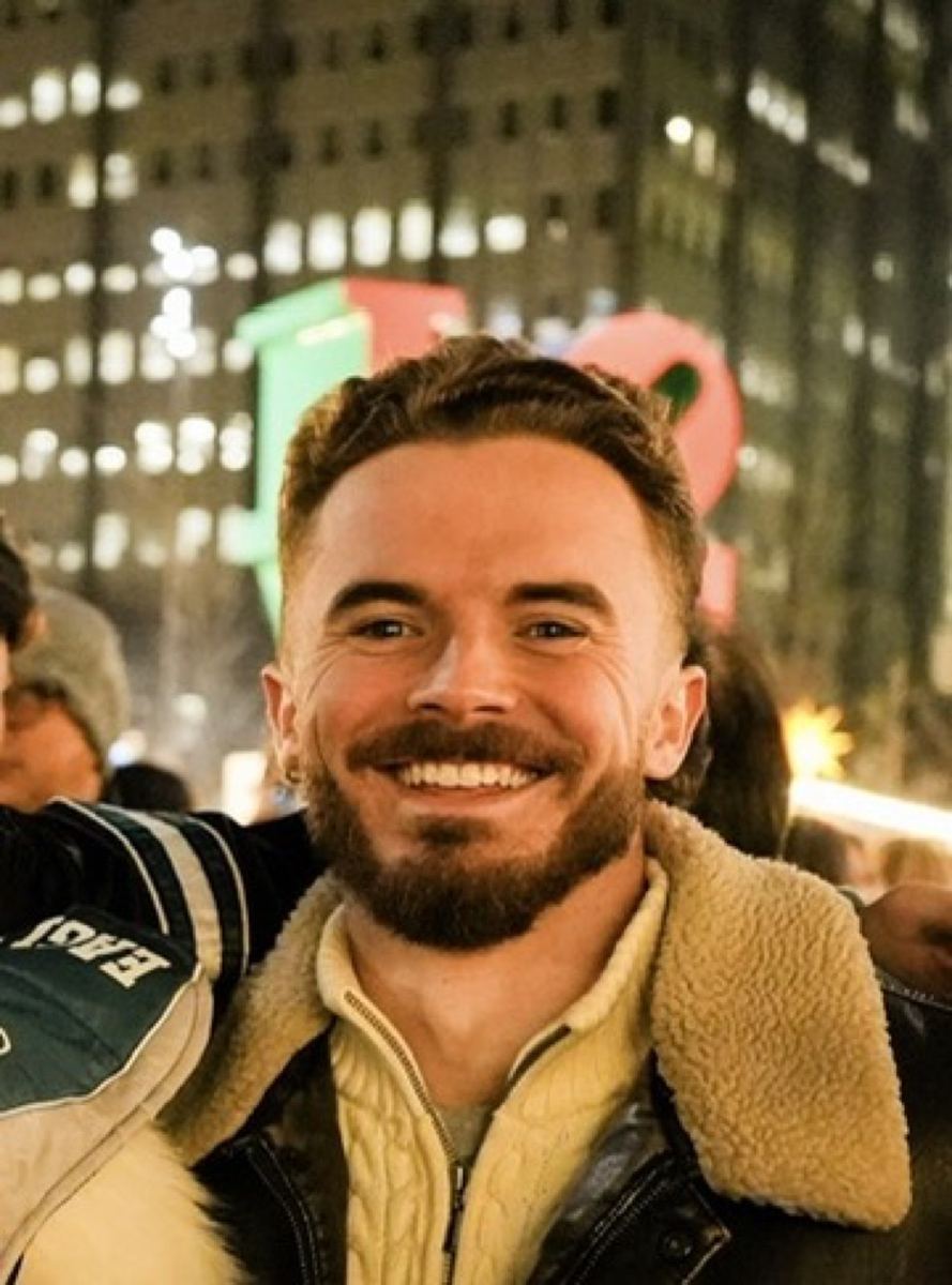 Andrew smiling in the city at night
