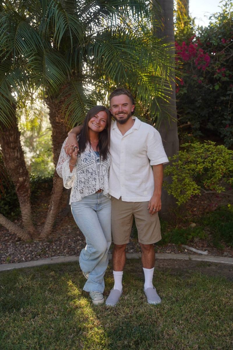 Andrew and Morgan smiling in front of palm trees