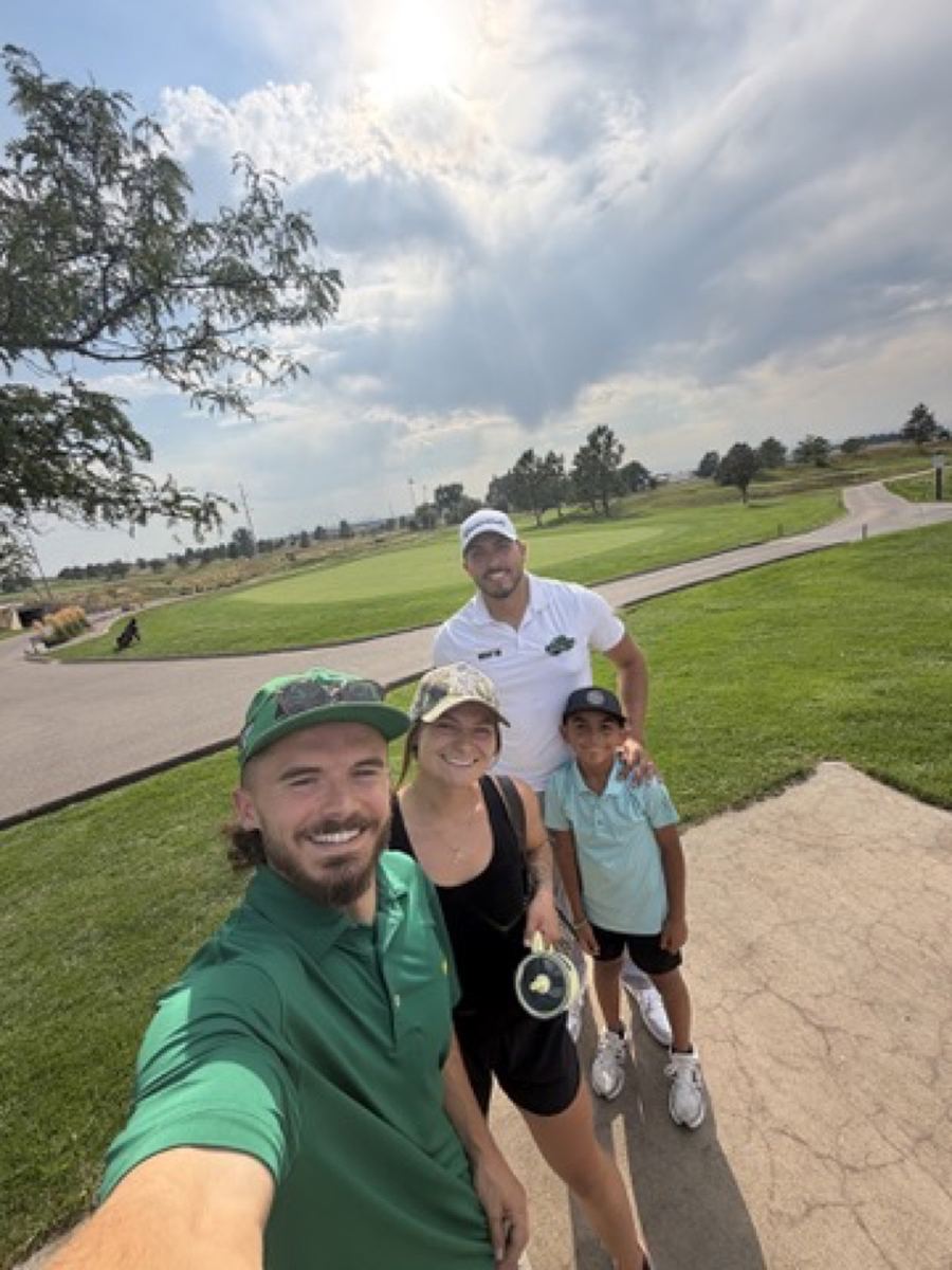 Andrew and Morgan on a golf course with friends